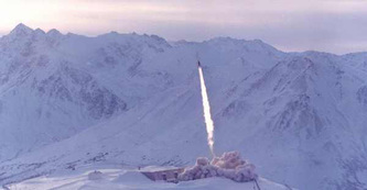 Hercules firing from Site Summit.  Mountain range in background.
